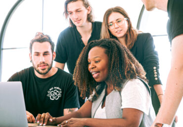 Diverse group individuals looking at the laptop